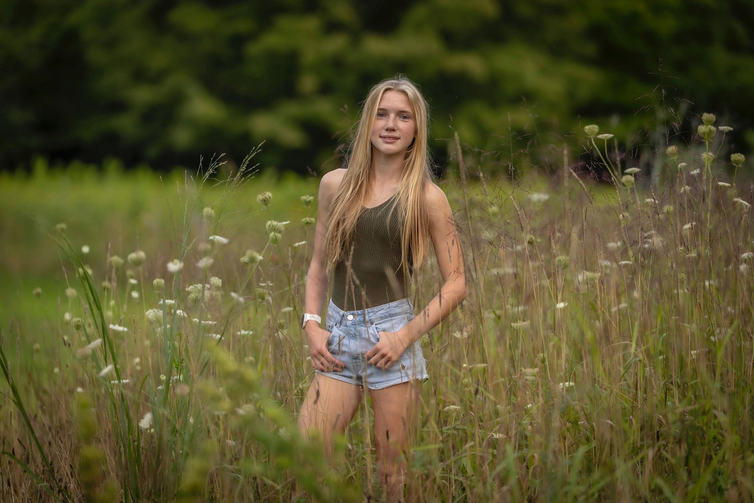 CT Senior Photographer | CT Photographer | West Hartford Senior Portraits | Smiling HS Senior in a tank top and shorts standing in a field of tall grass and flowers, photographed by Rob Faber Photography.