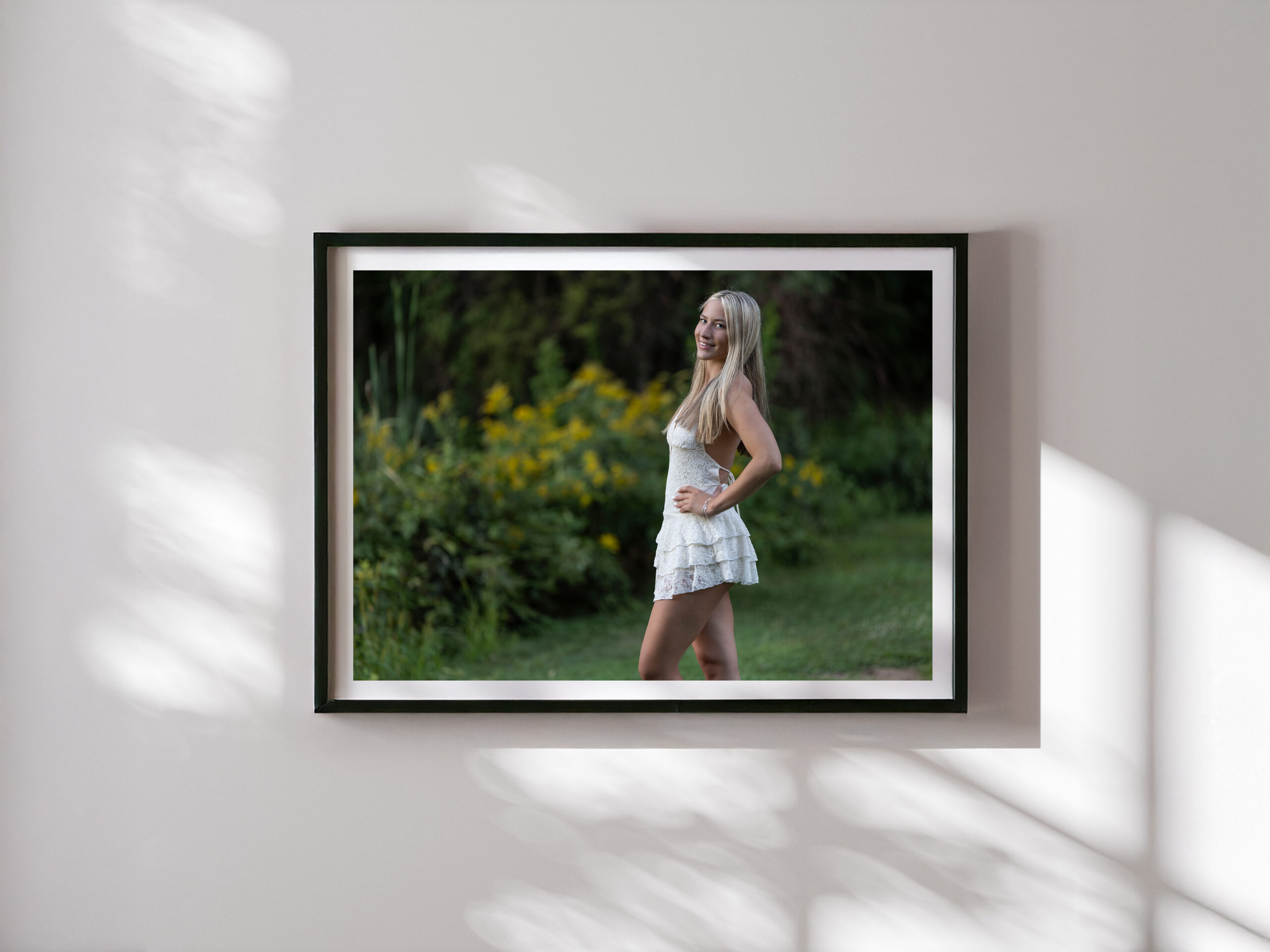 Framed senior portrait of a young woman in a white dress displayed on a wall with natural light | CT Senior Photographer | Suffield Photographer | Senior Photos