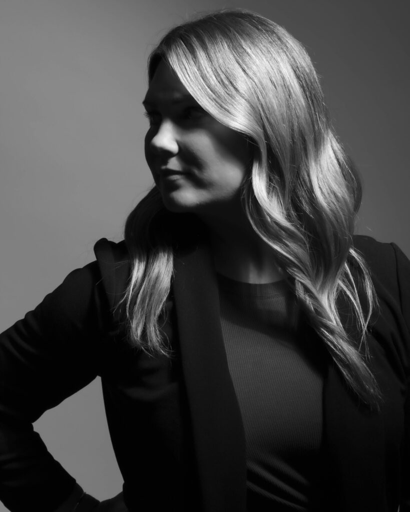 CT Headshot Photographer captures a dramatic black-and-white portrait of a confident woman in profile, styled in a dark blazer with cinematic side lighting for a bold, artistic look.