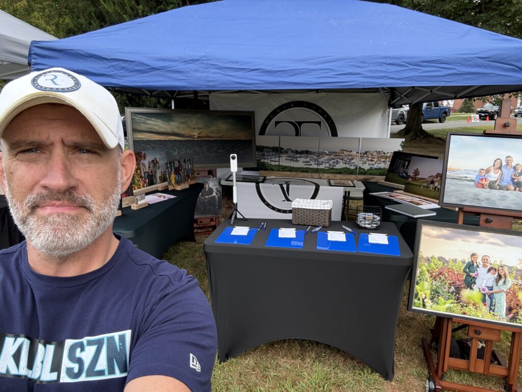 CT Photographer | CT Photographer | Rob Faber Photography – Booth display at Suffield on the Green featuring large framed family portraits, fine art wall pieces, and canvases with Rob Faber standing in front, showcasing the value of printed wall art.