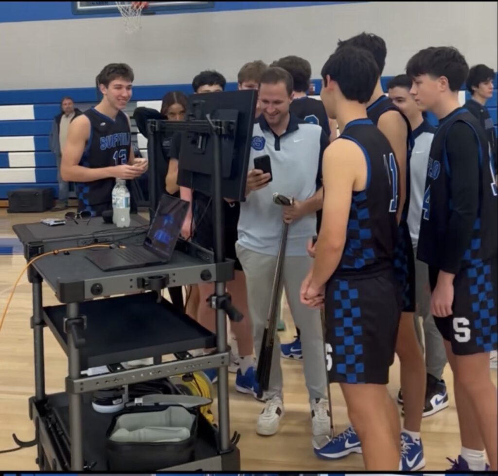 High school basketball team gathered around a tethered photography station to view images in real time during a professional CT sports media day.