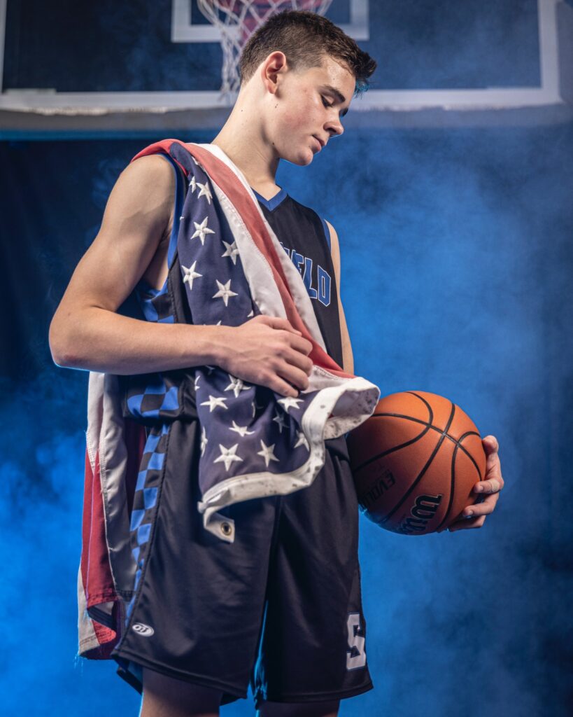 Basketball media day portrait of a high school athlete in Connecticut with dramatic studio lighting and American Flag