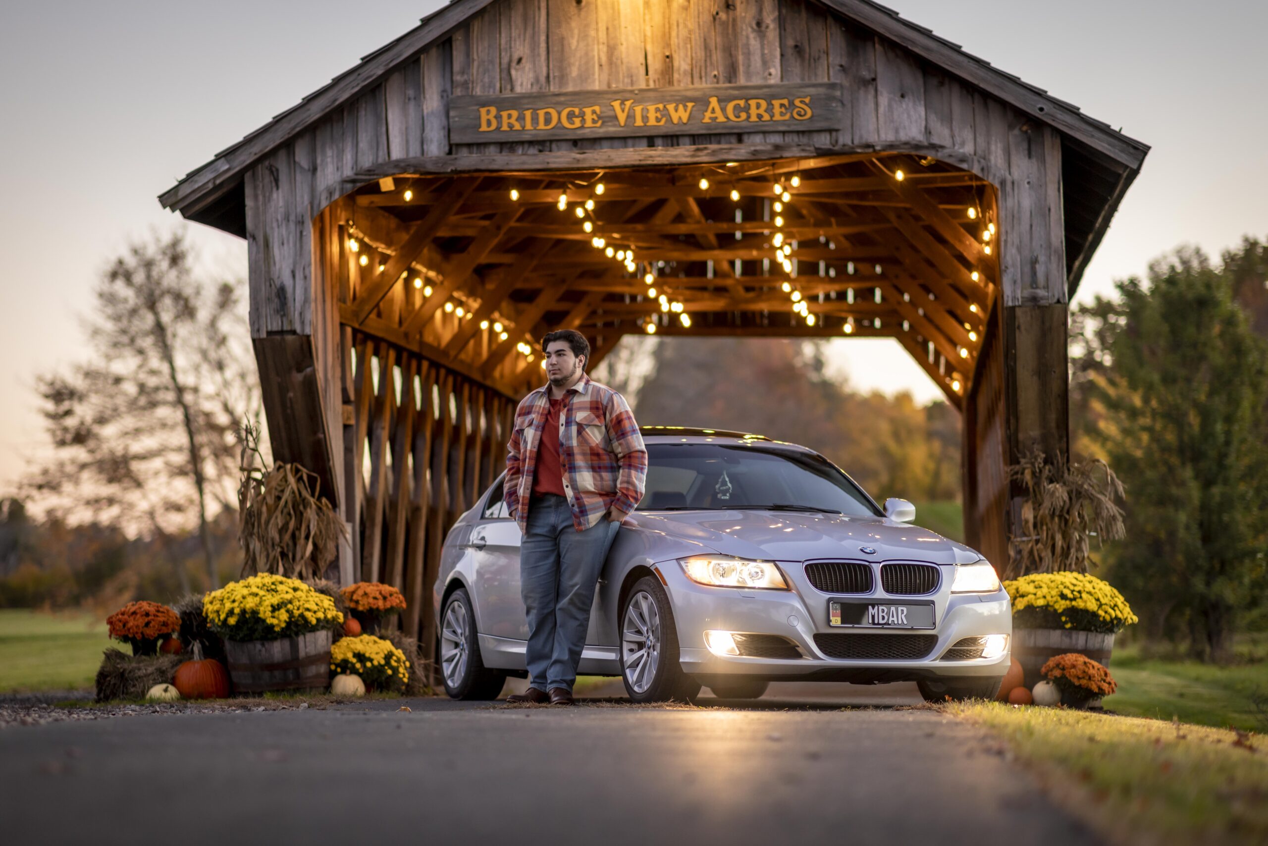 Rob Faber Photography | FBR Media | Senior Guys Portraits | Senior guy standing beside a luxury BMW under a covered bridge during an autumn portrait session in Connecticut