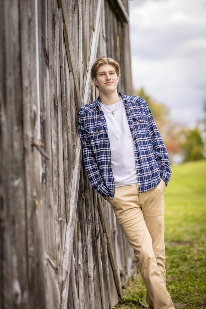 Rob Faber Photography | FBR Media | Senior Guys Portraits | Outdoor senior portrait of a high school guy leaning against a rustic barn wall during a relaxed Connecticut fall session
