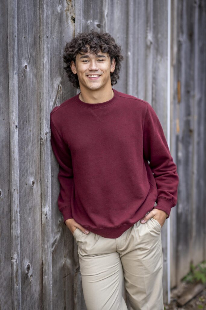 Rob Faber Photography | FBR Media | Senior Guys Portraits | Outdoor senior portrait featuring a high school guy in a burgundy sweatshirt with relaxed fall styling and natural light
