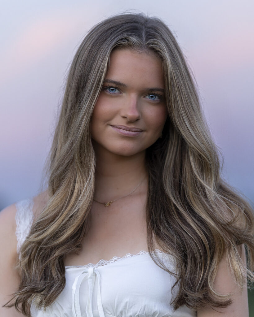 Rob Faber Photography | Headshot | Senior Photo | Girl with long hair at sunset with Pink sky behond her.